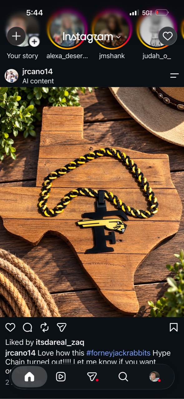 Justin’s black and gold hype chain with an F and rabbit pendant on a wooden Texas-shaped sign.
